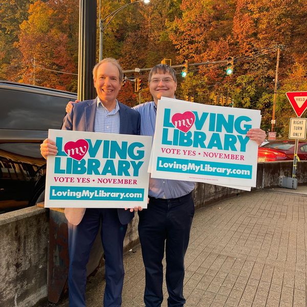 Campaign supporters holding Loving My Library signs